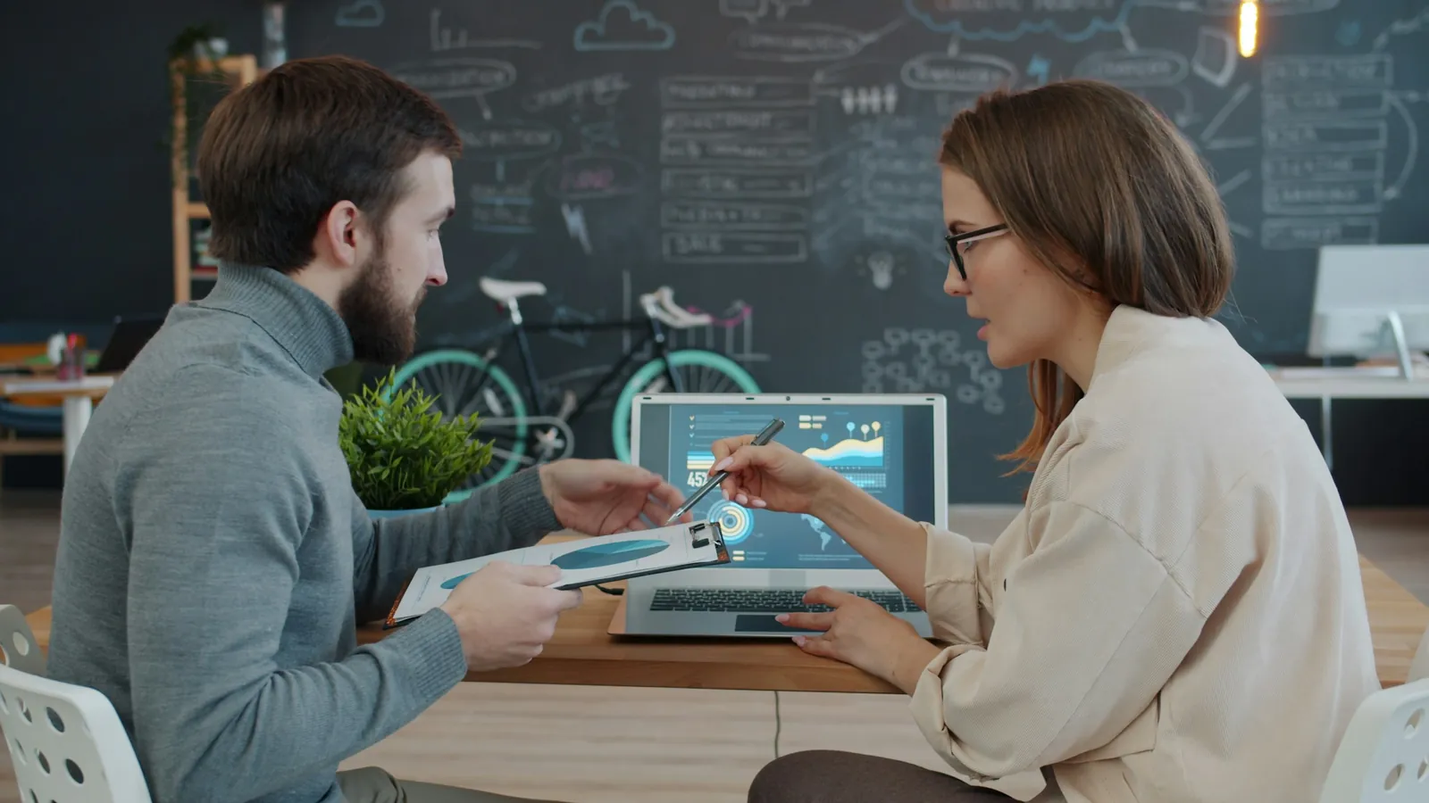 A wellness brand team reviewing brand health metrics on a laptop in a bright office, the numbers that show how a brand is remembered and chosen