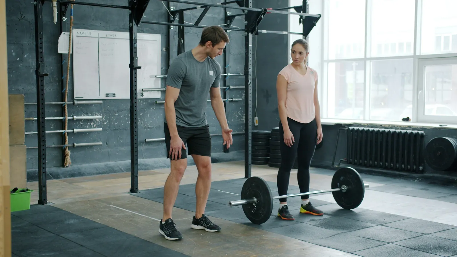 A fitness professional coaching a client during a daytime session, the working-day rhythm that marks the health and wellness workforce